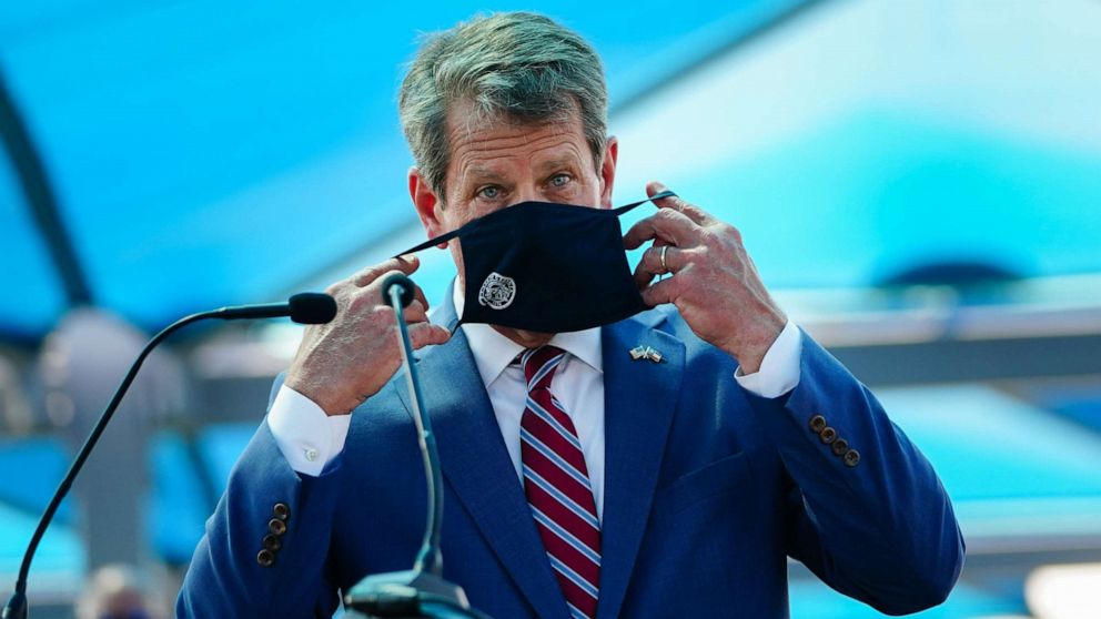 PHOTO: Georgia Gov. Brian Kemp puts on a mask after speaking at a press conference announcing statewide expanded COVID testing on Aug. 10, 2020 in Atlanta.