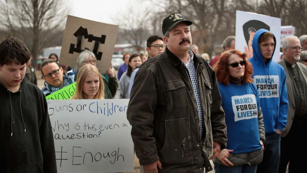 Randy Bryce (C) joins other residents at a rally to show support for students who finished the last leg of a 50-mile march through Wisconsin in the hometown of House Speaker Paul Ryan (R-WI) to call attention to gun violence, March 28, 2018, in Janesville, Wisc. 