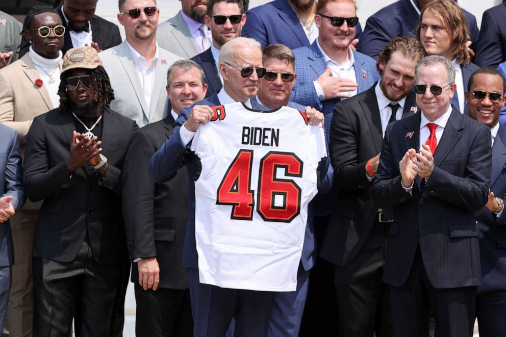 PHOTO: President Joe Biden poses with a Buccaneers jersey, next to owner Bryan Glazer, as he welcomes members of the NFL Super Bowl champion Tampa Bay Buccaneers to a reception at the White House in Washington, July 20, 2021.