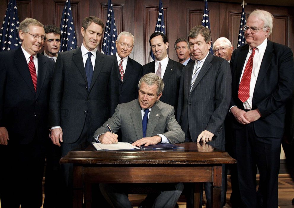 PHOTO: President George W. Bush surrounded by members of Congress, signs the Protection of Lawful Commerce in Arms Act at the Old Executive Office Building in Washington, D.C., Oct. 26, 2005.