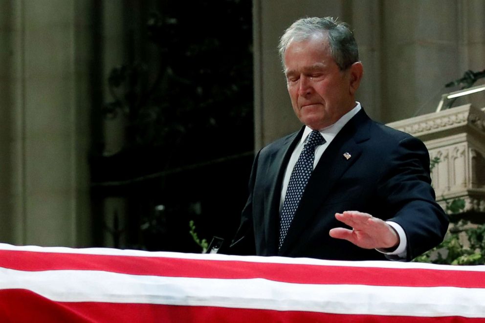 PHOTO: Former President George W. Bush touches the casket of his father, former President George H.W. Bush, at the State Funeral at the National Cathedral, Dec. 5, 2018, in Washington.