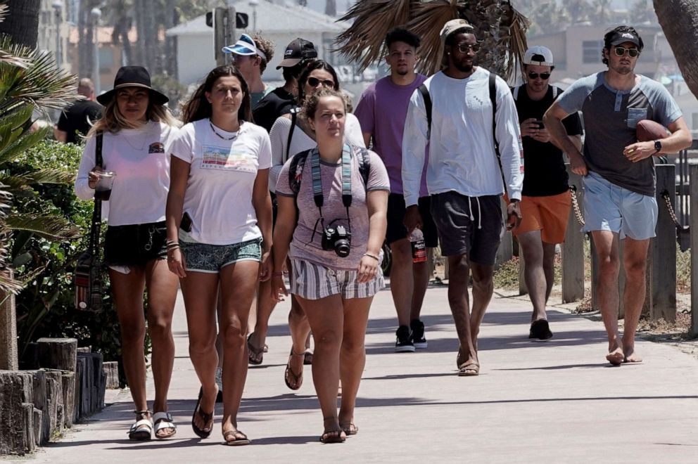 PHOTO: Young people without protective masks walk along the Pacific Beach boardwalk in San Diego, California, ahead of the Fourth of July holiday July 3, 2020.