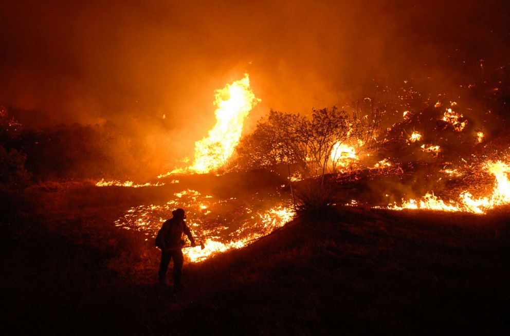 PHOTO: Eric Downard, with the Bureau of Land Management, digs a line attempting to contain a wild fire threatening homes on Hasley Canyon Road in Hasley Canyon, Calif., Oct. 22, 2007. 