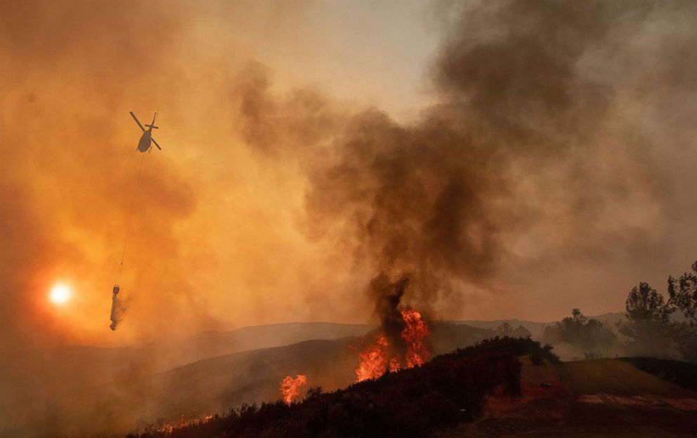 PHOTO: A helicopter drops water on a burning hillside during the Ranch Fire in Clearlake Oaks, Calif., Aug. 5, 2018.