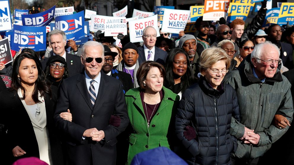 PHOTO: 2020 presidential candidates walk arm-in-arm with local African-American leaders during the Martin Luther King Jr. Day Parade in Columbia, South Carolina, Jan. 20, 2020.