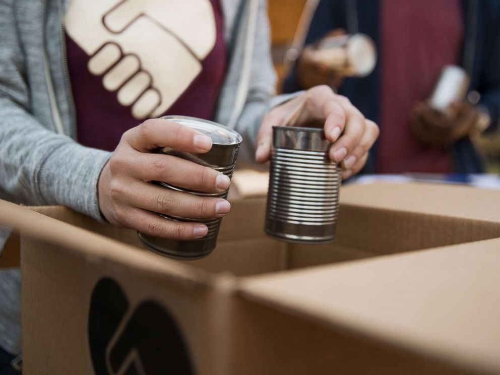 PHOTO: An undated stock photo depicts people packing boxes with canned food.