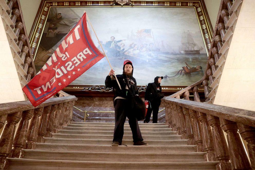 PHOTO: A protester holds a Trump flag inside the US Capitol Building near the Senate Chamber on Jan. 6, 2021 in Washington, DC. 