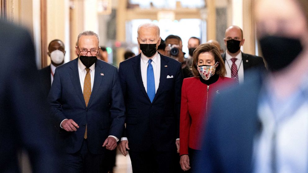 PHOTO: President Joe Biden joined by Senate Majority Leader Chuck Schumer and House Speaker Nancy Pelosi walk through the Hall of Columns before speaking during a ceremony on the first anniversary of the January 6 attack in, Jan. 6, 2022. 