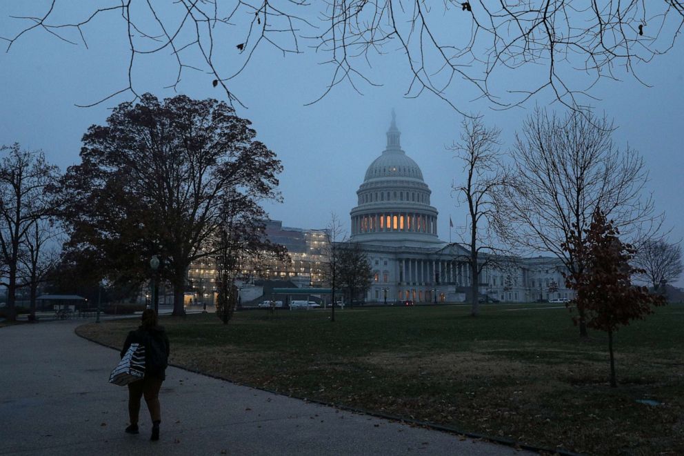 PHOTO: A woman walks past the U.S. Capitol dome early in the morning on another day of the continued impeachment inquiry hearings into President Donald Trump's dealings with Ukraine on Capitol Hill in Washington, D.C., Dec. 9, 2019.