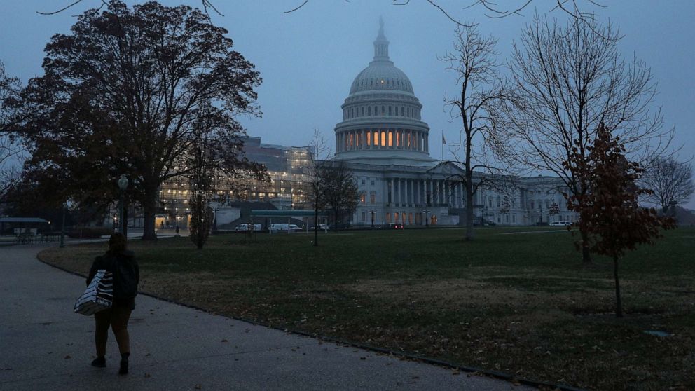 PHOTO: A woman walks past the U.S. Capitol dome early in the morning on another day of the continued impeachment inquiry hearings into President Donald Trump's dealings with Ukraine on Capitol Hill in Washington, D.C., Dec. 9, 2019.