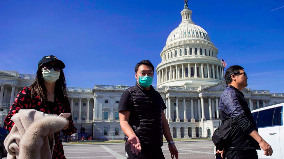 PHOTO: A tour operator, wearing a protective mask, gestures as he leads a tour near the Capitol in Washington,March 9, 2020. 