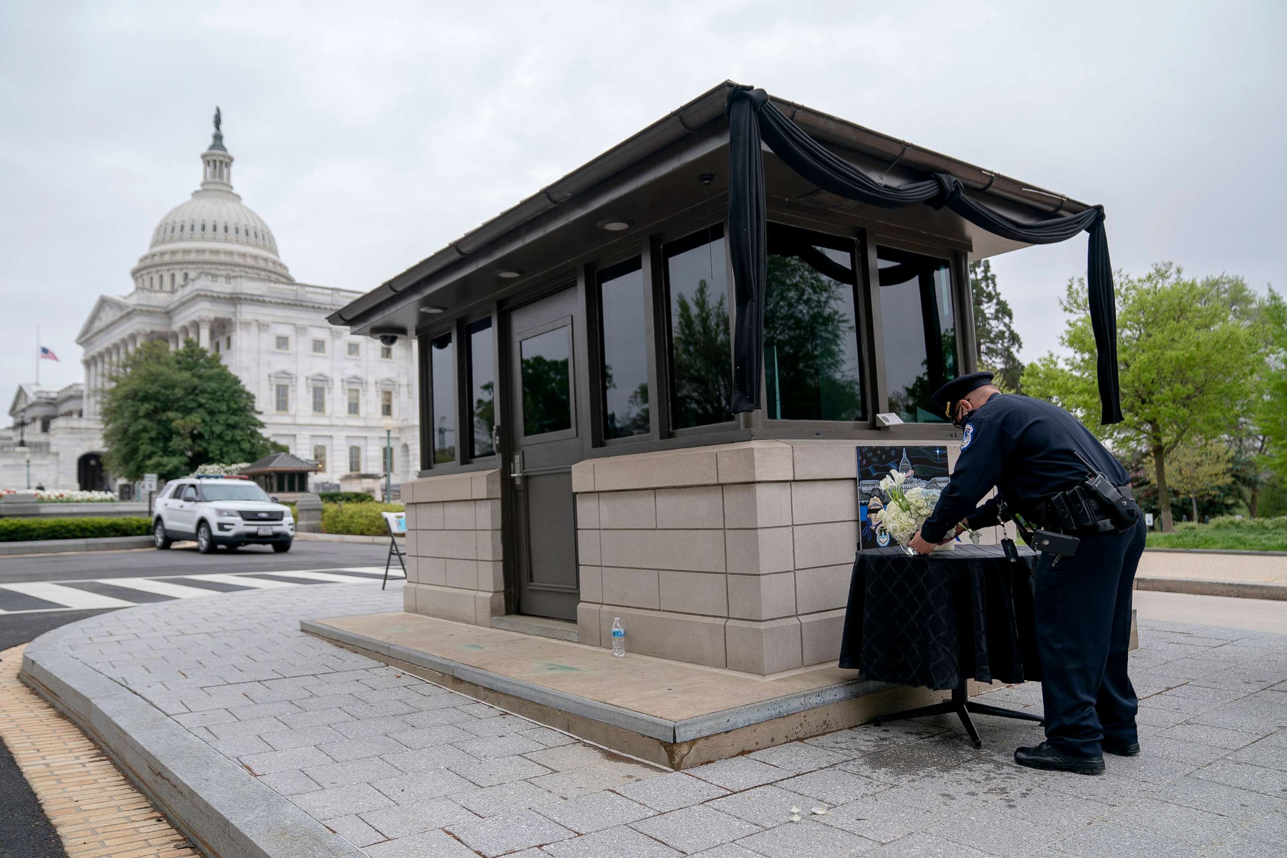 PHOTO: A Capitol Police Officer places flowers in a memorial for Officer William Evans outside the U.S. Capitol, April 13, 2021, in Washington, D.C.