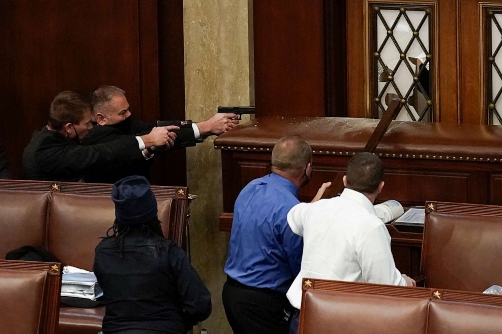 PHOTO: U.S. Capitol Police with guns drawn watch as rioters try to break into the House Chamber at the U.S. Capitol on Jan. 6, 2021, in Washington, D.C. 