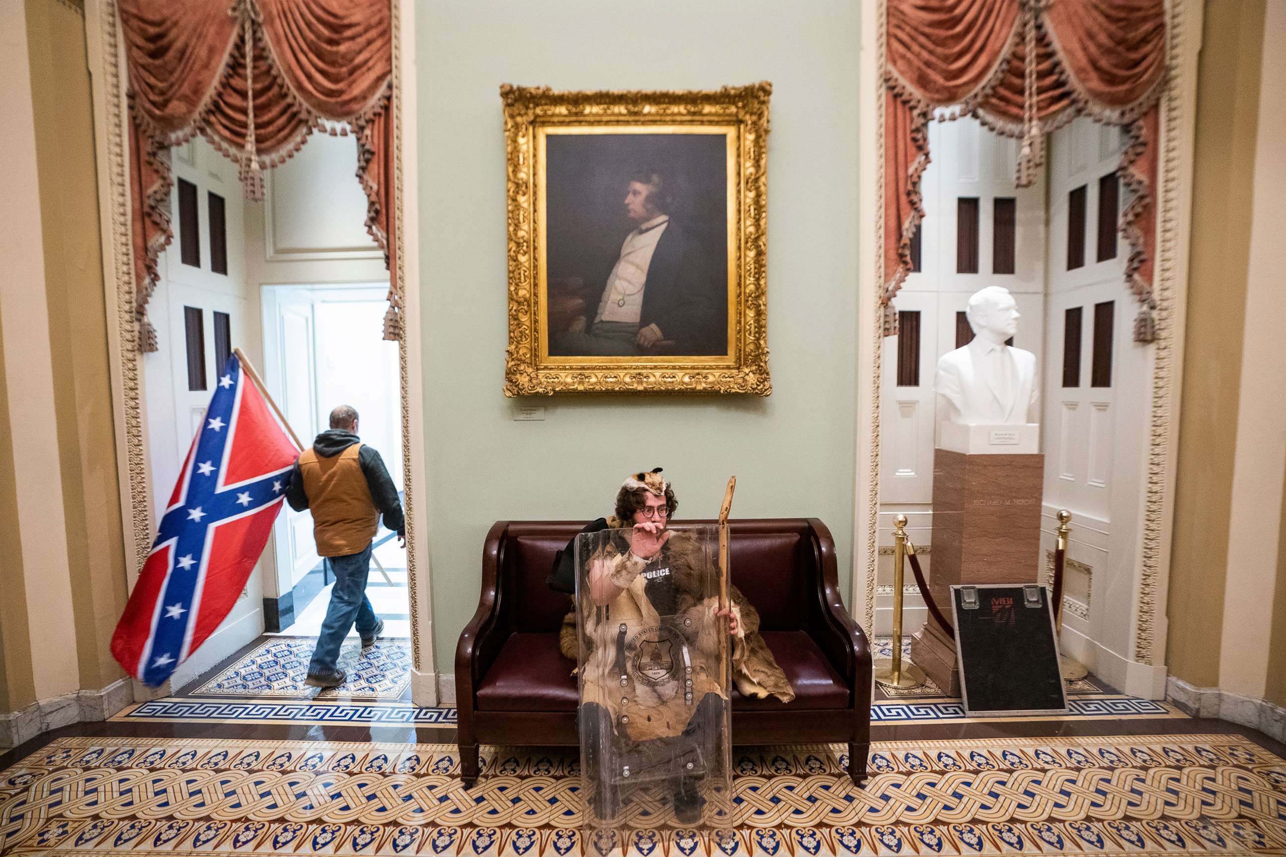 A supporter of President Donald Trump, Aaron Mostofsky who is identified in his arrest warrant, sits outside the Senate chamber after breaching Capitol security in Washington, Jan. 6, 2021.