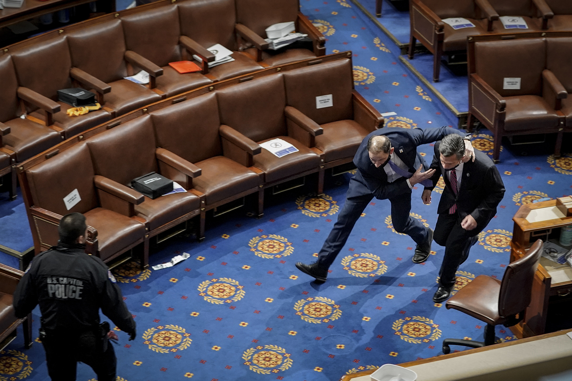 PHOTO: A member of the U.S. Capitol police rushes Rep. Dan Meuser out of the House Chamber as protesters try to enter the House Chamber during a joint session of Congress in Washington, Jan. 06, 2021.