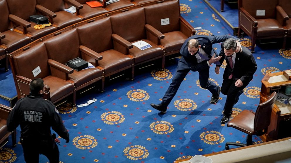 PHOTO: A member of the U.S. Capitol police rushes Rep. Dan Meuser out of the House Chamber as protesters try to enter the House Chamber during a joint session of Congress in Washington, Jan. 06, 2021.