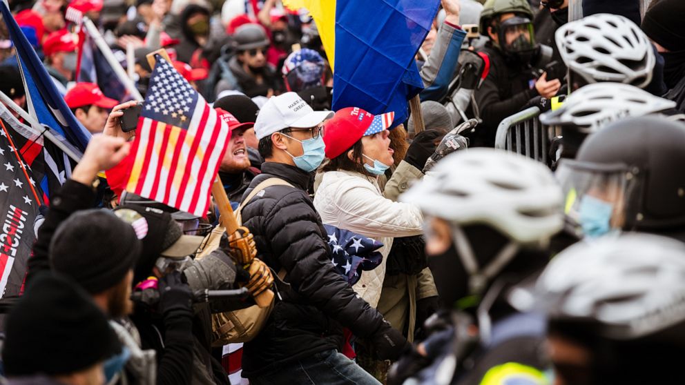 PHOTO: Pro-Trump protesters face a line of police officers after breaking through barriers onto the grounds of the Capitol Building, Jan. 6, 2021.