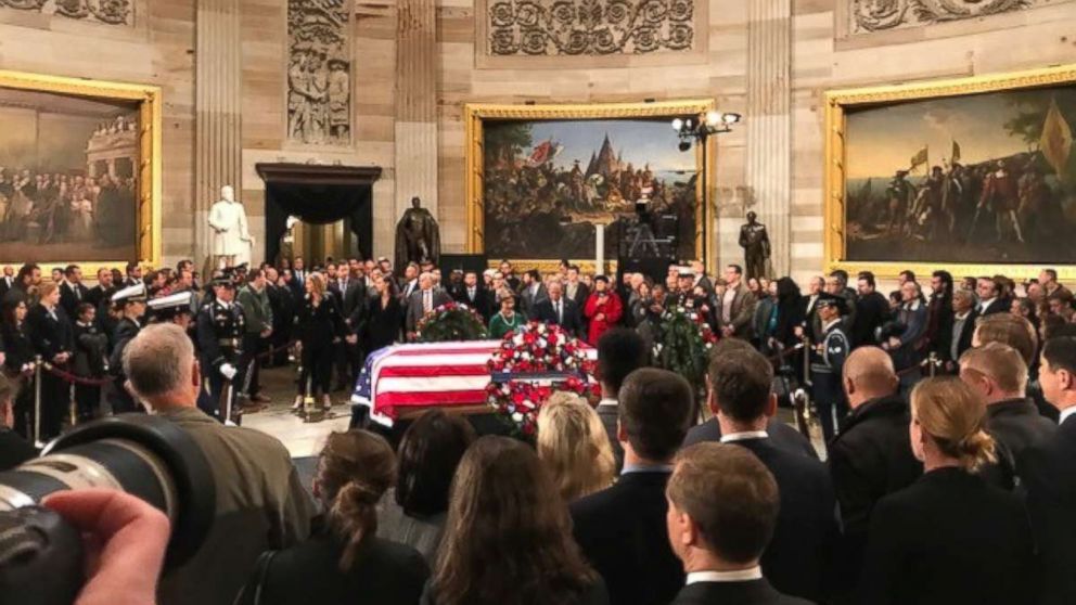 PHOTO: Former President George W. Bush and first lady Laura Bush stand in front of his father's casket as thousands of onlookers gather in the Capitol Rotunda on Tuesday, Dec. 4, 2018.