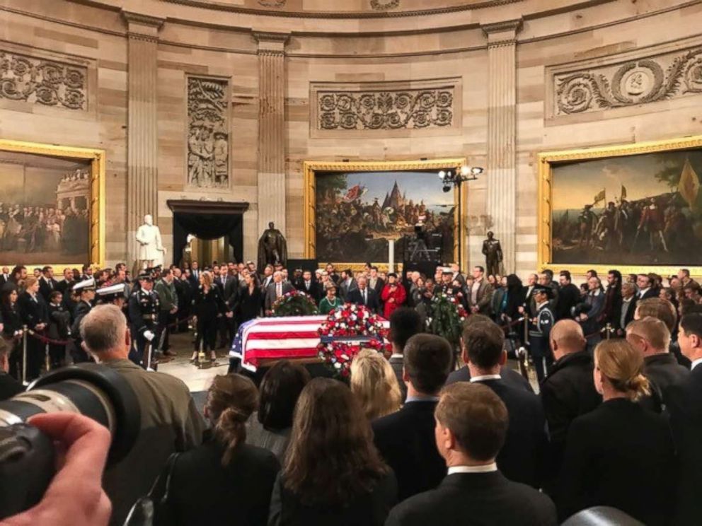 PHOTO: Former President George W. Bush and first lady Laura Bush stand in front of his father's casket as thousands of onlookers gather in the Capitol Rotunda on Tuesday, Dec. 4, 2018.