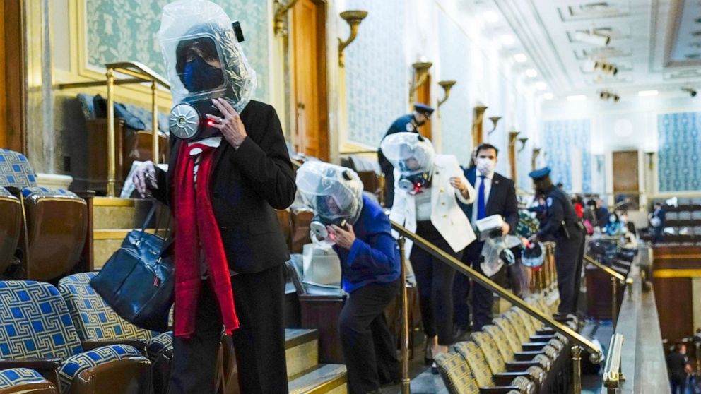 PHOTO: People shelter in the House gallery as protesters try to break into the House Chamber at the Capitol, Jan. 6, 2021.