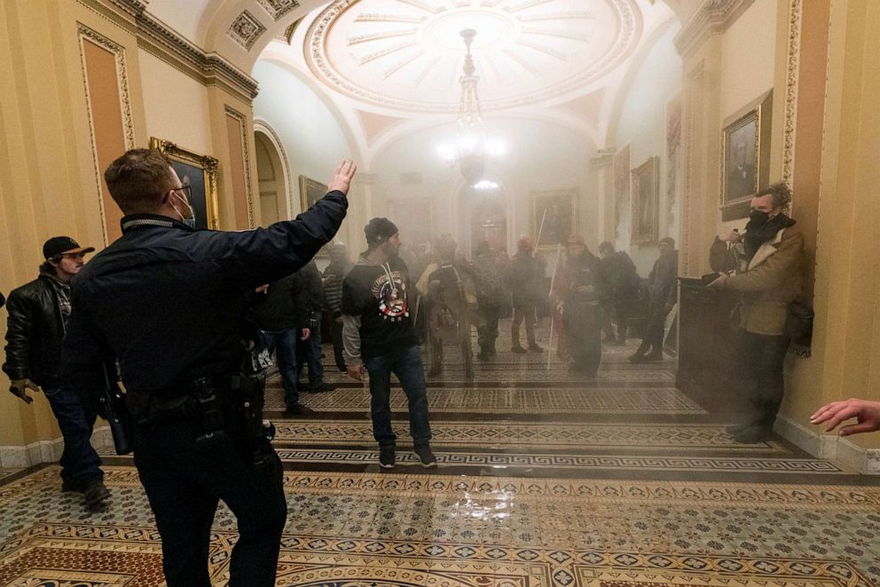 PHOTO: Smoke fills the walkway outside the Senate Chamber as rioters are confronted by U.S. Capitol Police officers inside the Capitol in Washington, Jan. 6, 2021.