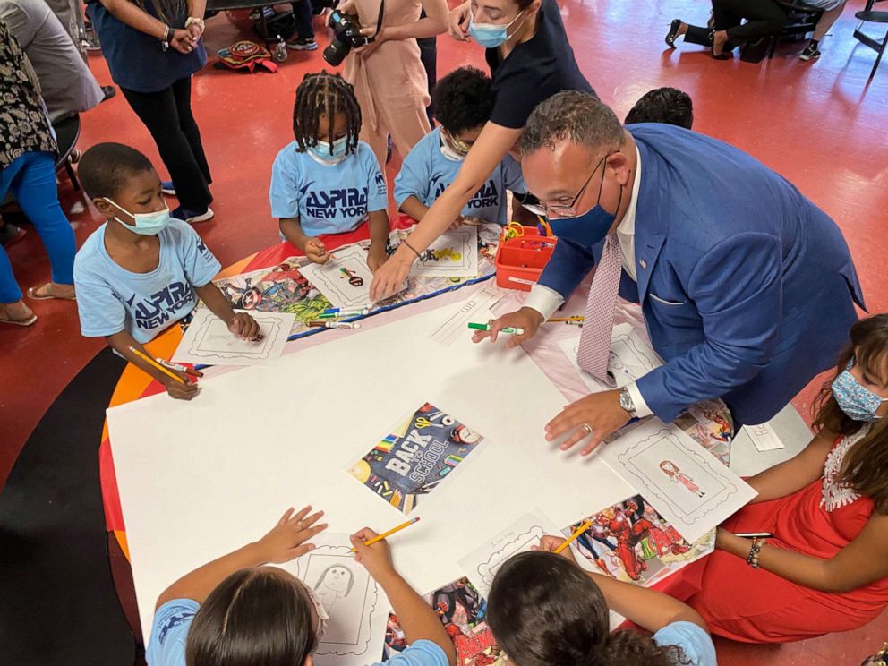 PHOTO: U.S. Education Secretary Miguel Cardona draws a "Welcome Back" poster with students at P.S. 5 Port Morris in the Bronx borough of New York.