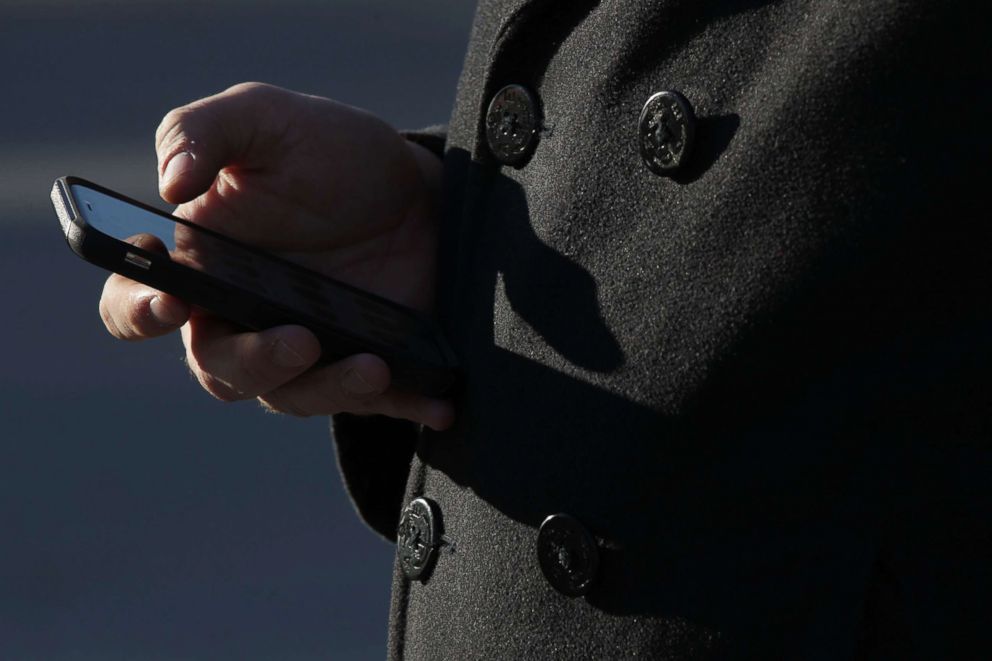 PHOTO: A man checks his cell phone as he waits in line to enter the Supreme Court to hear Carpenter v. United States Nov. 29, 2017 in Washington, DC.