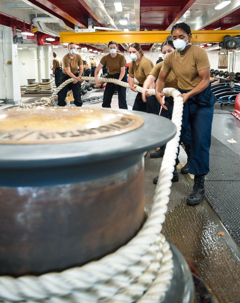 PHOTO: Sailors assigned to the aircraft carrier USS Theodore Roosevelt (CVN 71) handle mooring line, May 21, 2020, following an extended visit to Guam in the midst of the COVID-19 global pandemic.