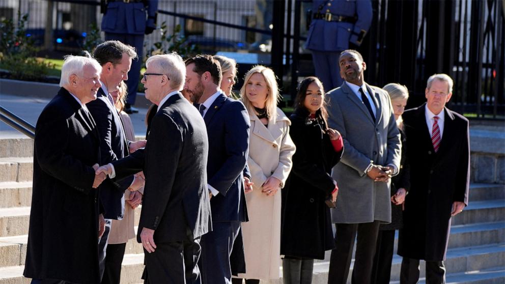 PHOTO: Jack Carter, and grandson Jason Carter greet officials as the hearse carrying the casket of former President Jimmy Carter pauses outside the State Capitol in Atlanta, Jan. 4, 2025.  