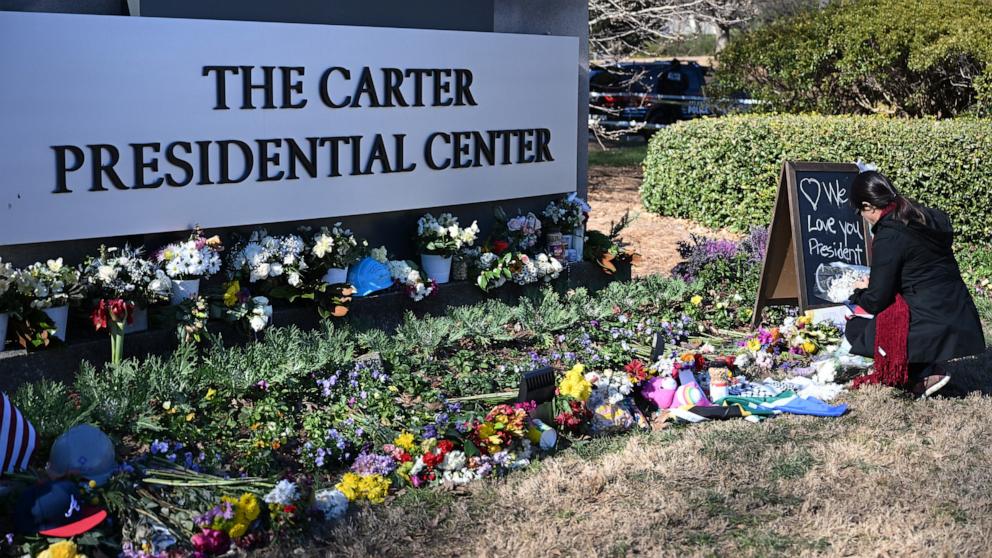 PHOTO: Angela Abreu lays flowers at a memorial for former US President Jimmy Carter in front of the Carter Presidential Center in Atlanta, Georgia on Jan. 4, 2025.