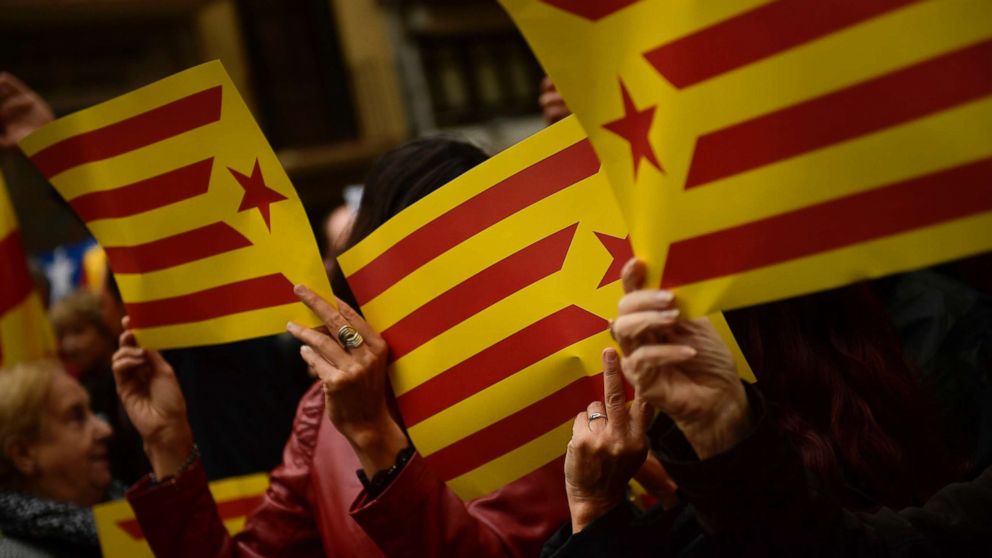 People display Catalonia independence flags during a gathering, Sept. 22, 2017, to protest the judicial and police operation against the planned October 1 independence referendum in Catalonia, Spain.