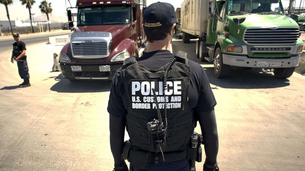 PHOTO: A U.S. Customs and Border Protection (CBP) officer stands in front of a line of trucks that will undergo a secondary inspection at the Otay Mesa Cargo Port of Entry in San Diego, on May 23, 2017.