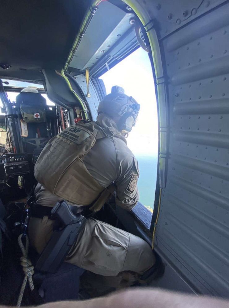 PHOTO: A CBP air and maritime federal agent looks out of a helicopter onto downtown Los Angeles ahead of Super Bowl LVI, on Feb. 8, 2022.