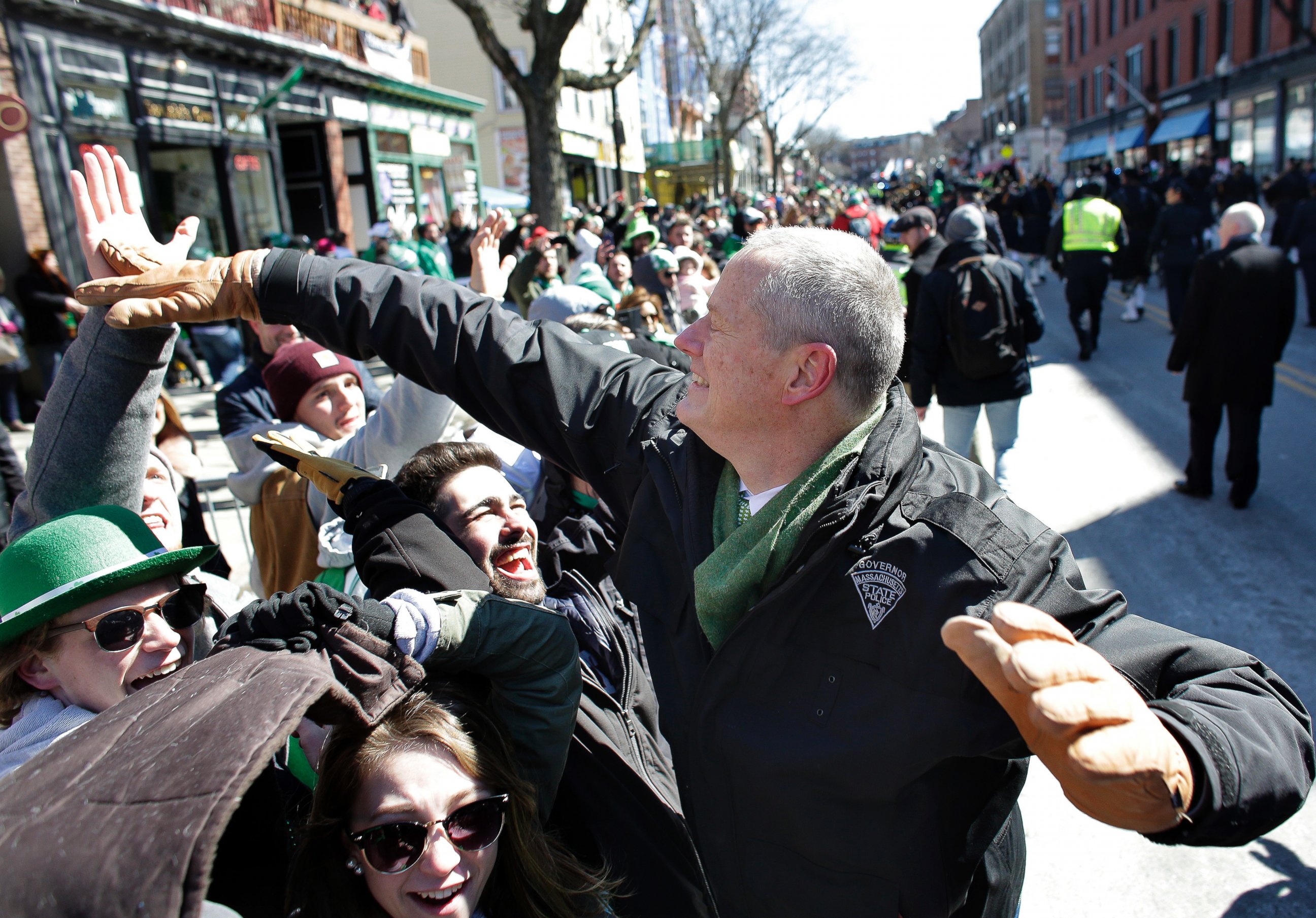 Massachusetts Gov. Charlie Baker, right, greets people in the crowd during the annual St. Patrick's Day parade, Sunday, March 18, 2018, in Boston.