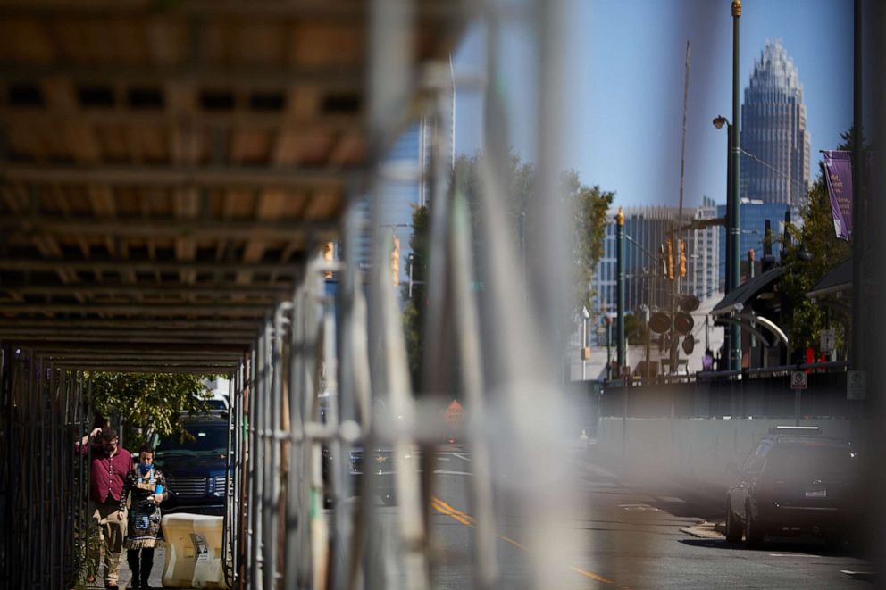 PHOTO: Pedestrians walk under scaffolding in the South End neighborhood of Charlotte, N.C., Sept. 21, 2020.