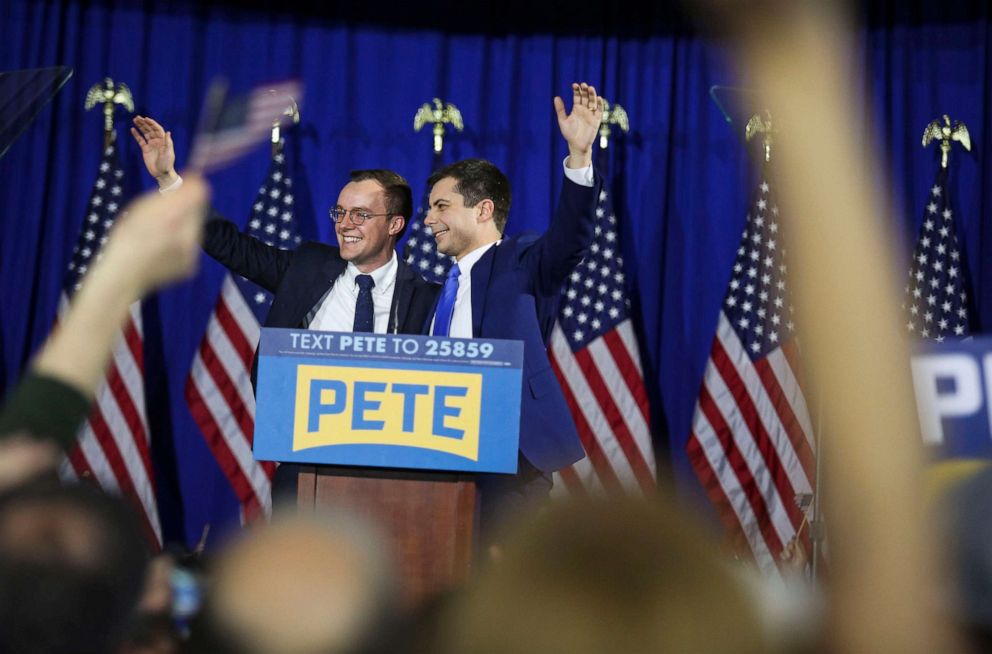 PHOTO: Pete Buttigieg, right, waves to the crowd with his husband Chasten Buttigieg at his primary watch party in Nashua, N.H., Feb. 11, 2020.