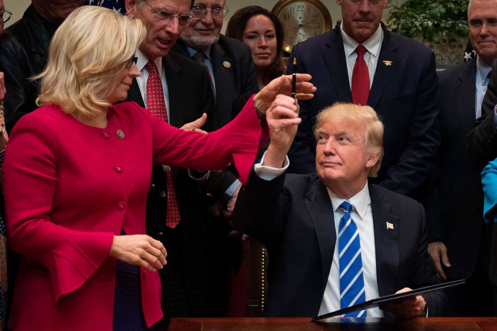 PHOTO: FILE - US President Donald Trump gives a pen to US Congresswoman Liz Cheney at the White House in Washington, DC, March 27, 2017.