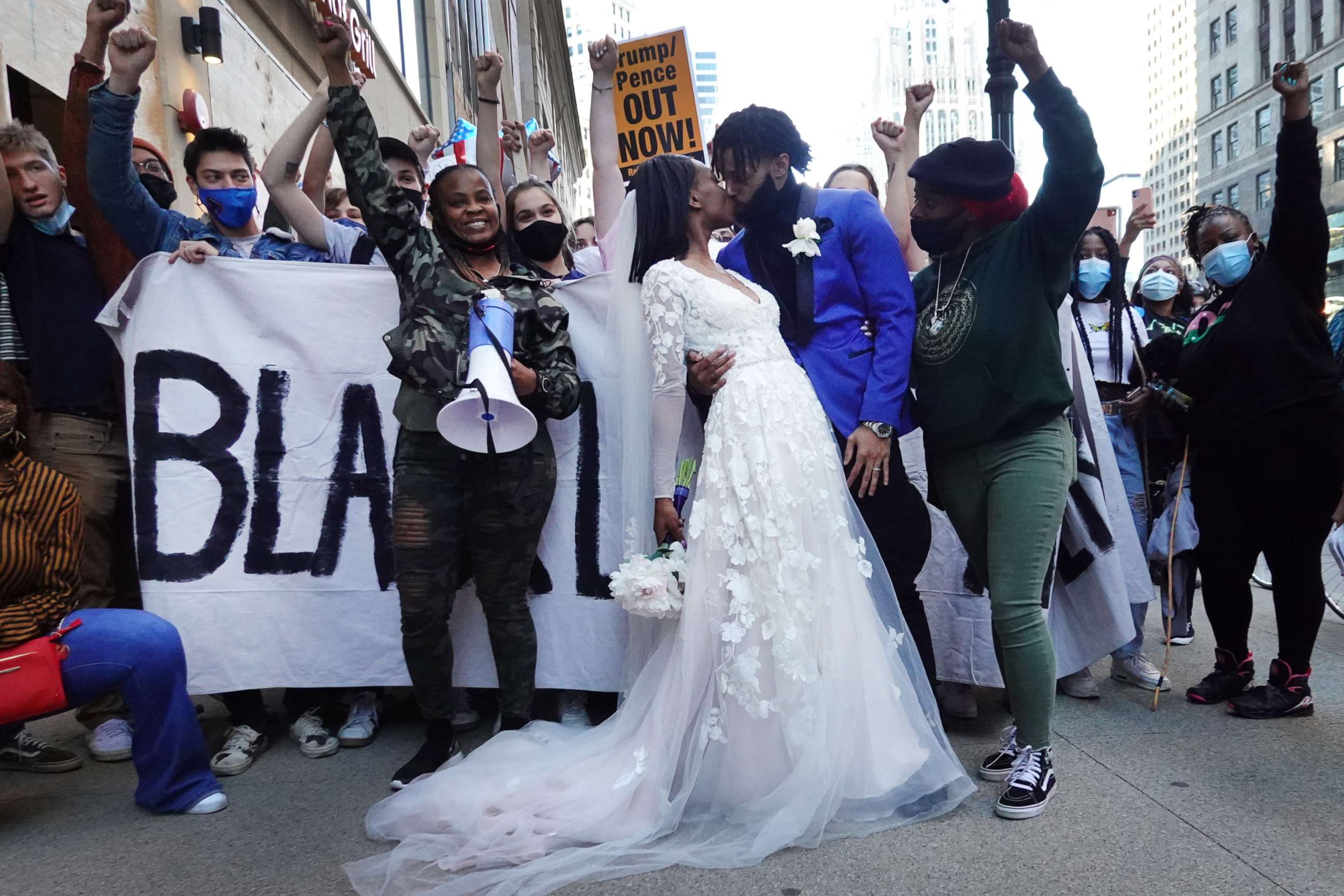 PHOTO: Julian and Fatimah Miller stop to grab a memory on their wedding day with a group of supporters of President-elect Joe Biden as they celebrate downtown on Nov. 07, 2020 in Chicago.