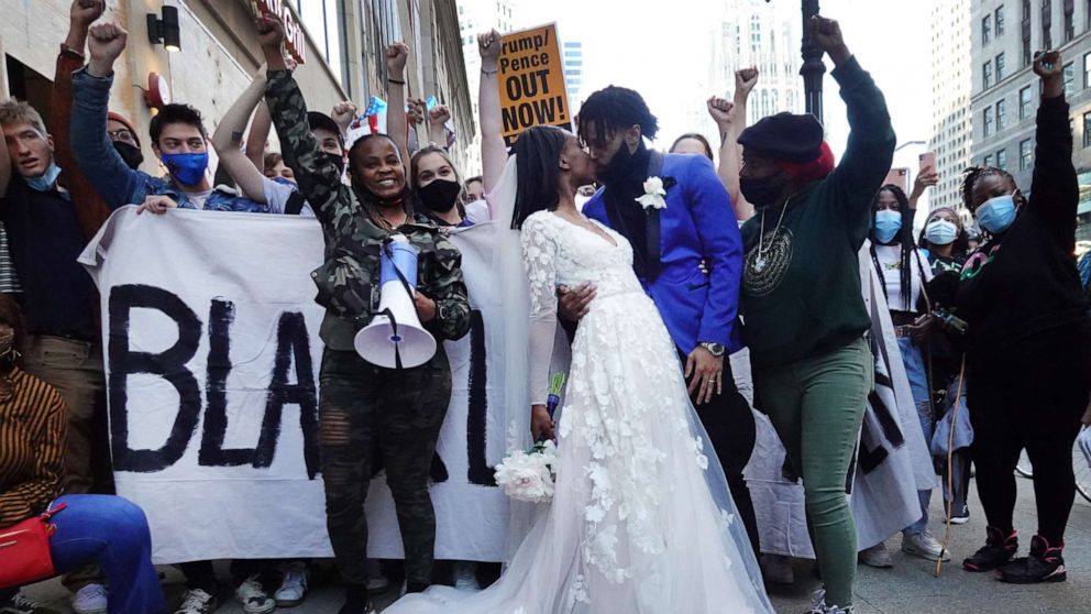 PHOTO: Julian and Fatimah Miller stop to grab a memory on their wedding day with a group of supporters of President-elect Joe Biden as they celebrate downtown on Nov. 07, 2020 in Chicago.