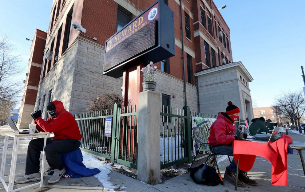 PHOTO: Michael Smith, left, and Jackson Potter, members of the Chicago Teachers Union executive board, stage a teach-out on Jan. 21, 2021, at Seward Communication Arts Academy in Chicago to protest Chicago Public Schools reopening plan.