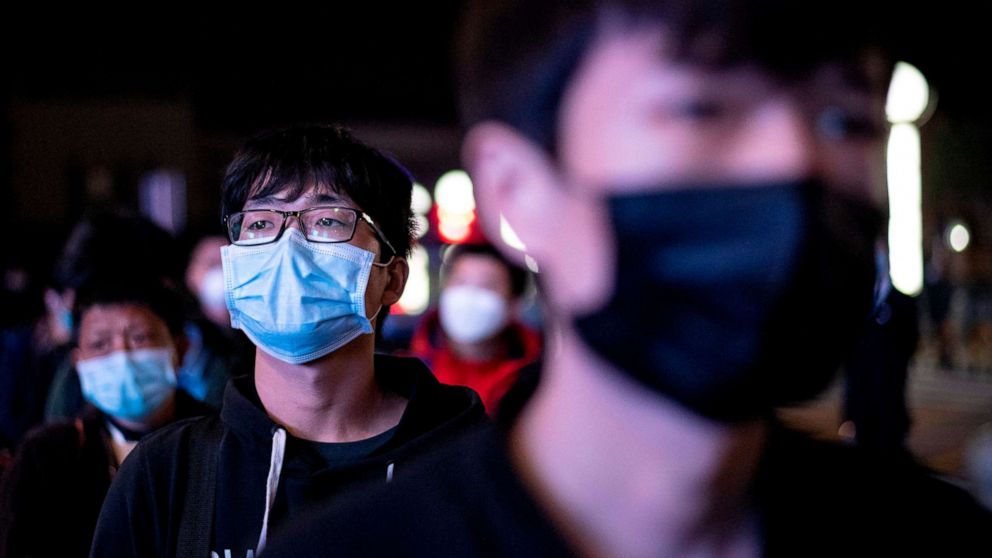 PHOTO: Passengers wear facemasks as they form a queue at the Wuhan Wuchang Railway Station in Wuhan, early April 8, 2020, as they prepare to leave the city in China's central Hubei province. 