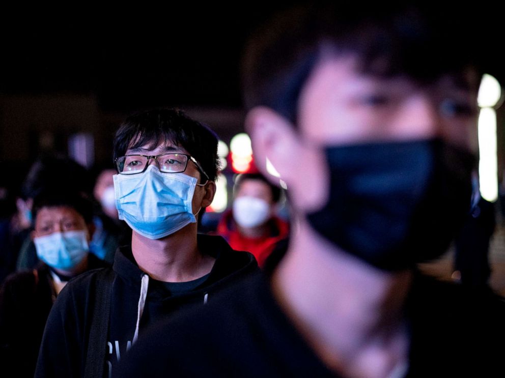 PHOTO: Passengers wear facemasks as they form a queue at the Wuhan Wuchang Railway Station in Wuhan, early April 8, 2020, as they prepare to leave the city in China's central Hubei province. 