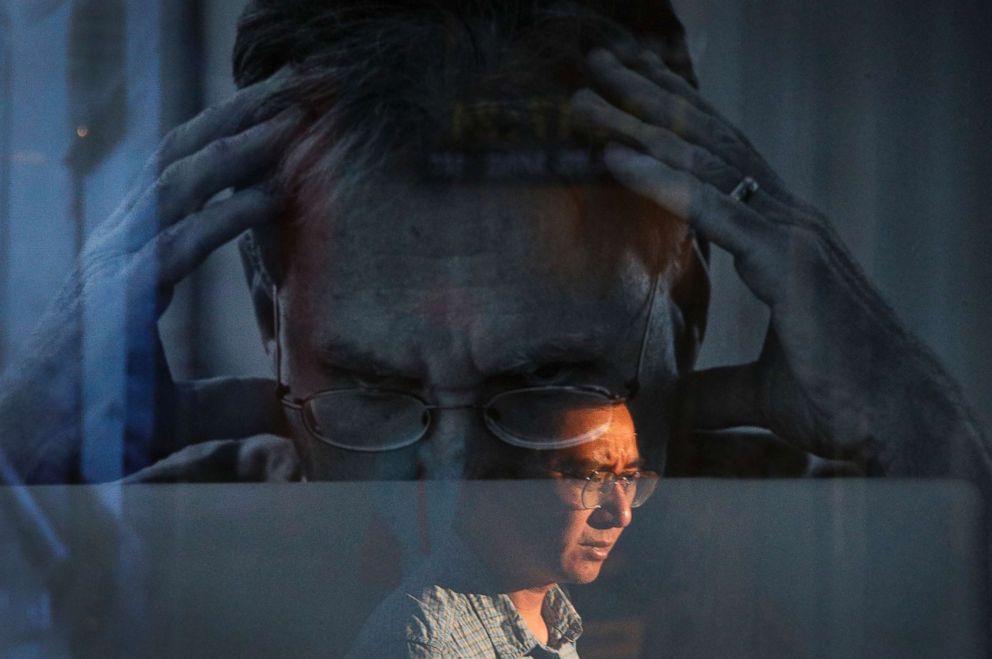 PHOTO: A man is reflected on an advertisement for Apple's MacBook computer on display near a shopping mall in Beijing, Sept. 6, 2018.