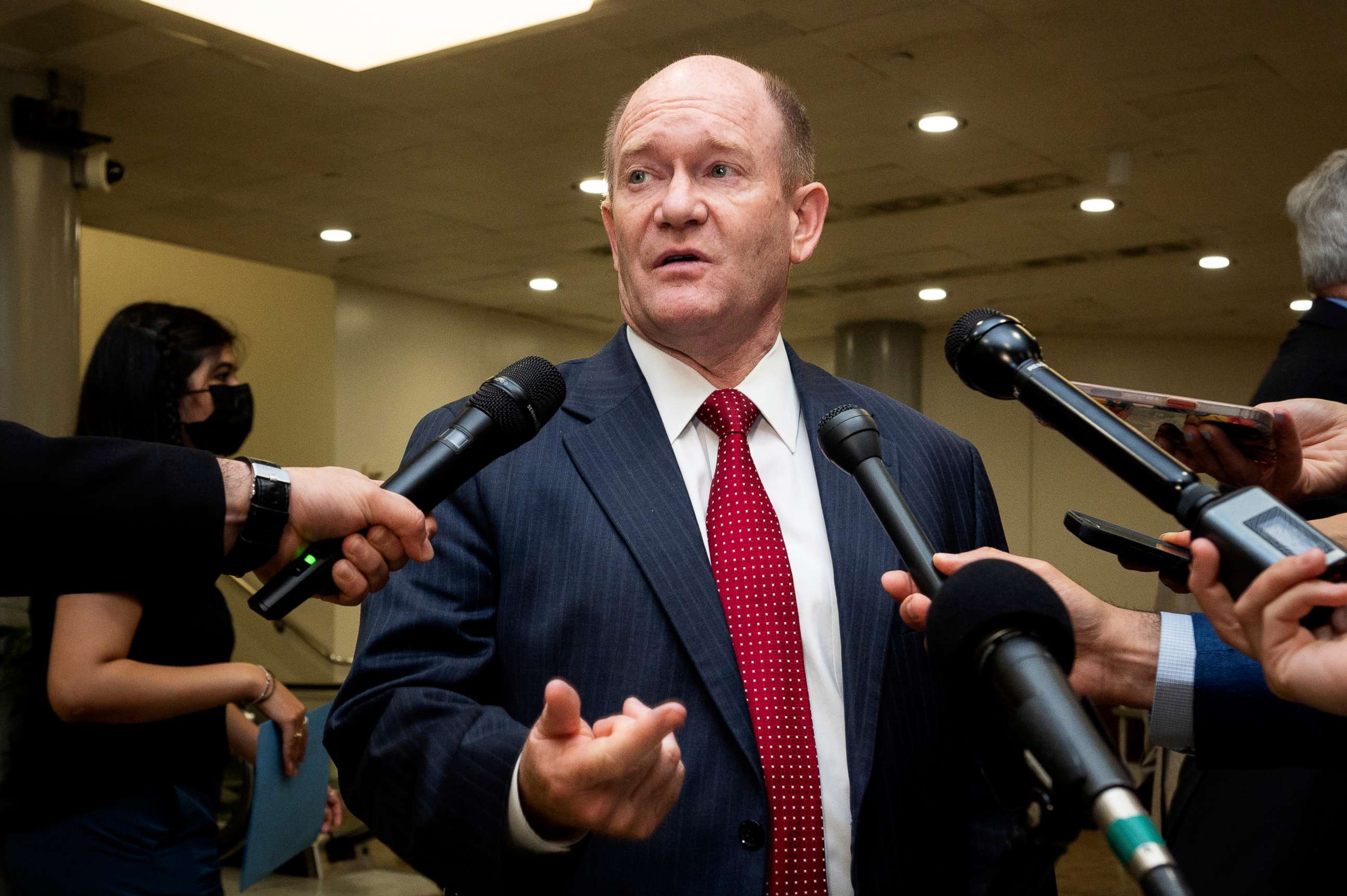 PHOTO: Sen. Chris Coons speaks with reporters near the Senate Subway at the U.S. Capitol.