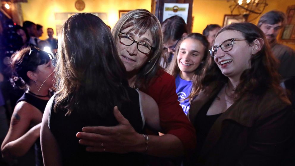 Vermont Democratic gubernatorial candidate Christine Hallquist, center, a transgender woman and former electric company executive, embraces supporters after claiming victory during her election night party in Burlington, Vt., Tuesday, Aug. 14, 2018. 