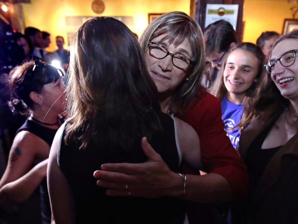 Vermont Democratic gubernatorial candidate Christine Hallquist, center, a transgender woman and former electric company executive, embraces supporters after claiming victory during her election night party in Burlington, Vt., Tuesday, Aug. 14, 2018.