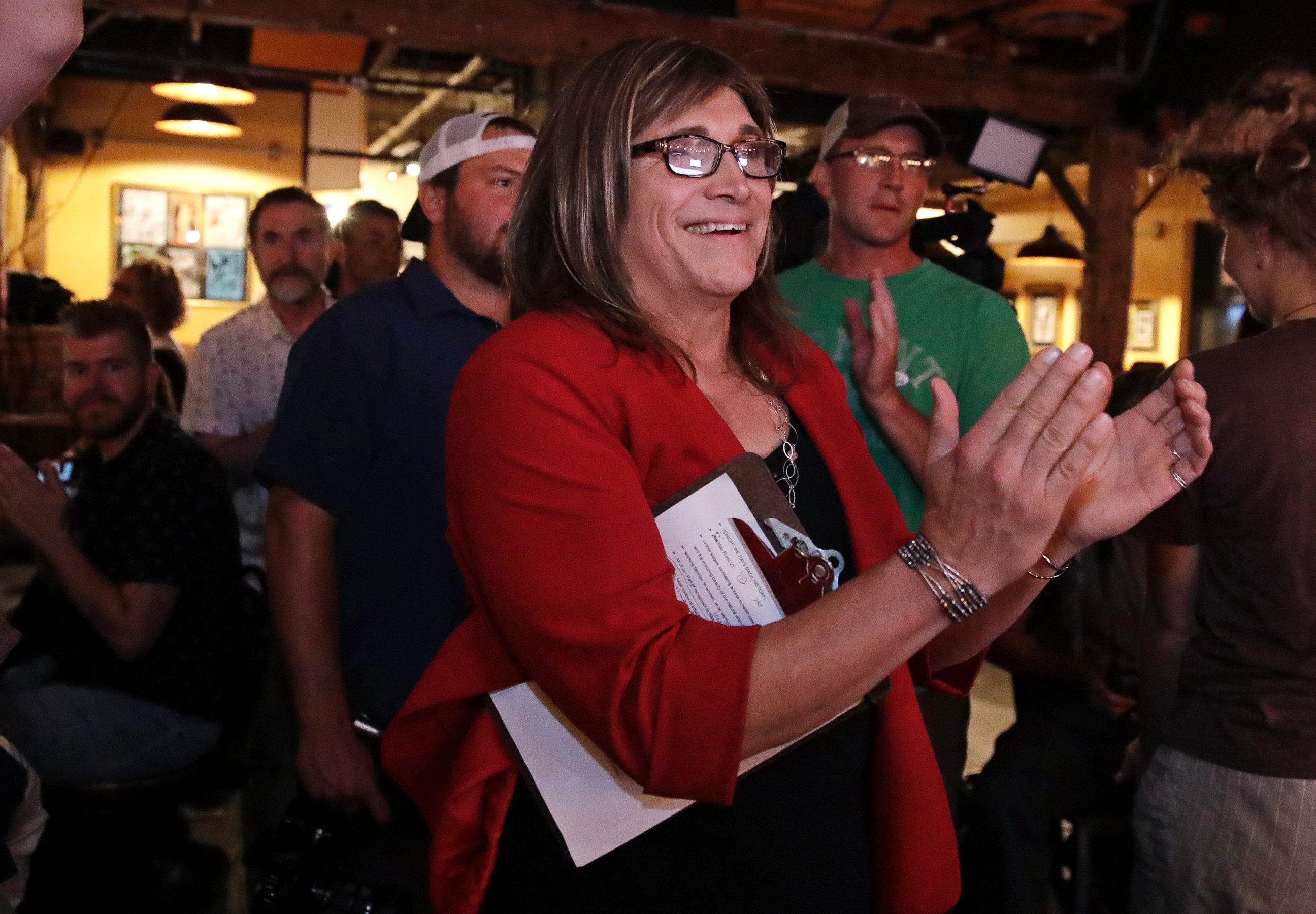 Vermont Democratic gubernatorial candidate Christine Hallquist, center, a transgender woman and former electric company executive, embraces supporters after claiming victory during her election night party in Burlington, Vt., Tuesday, Aug. 14, 2018. 