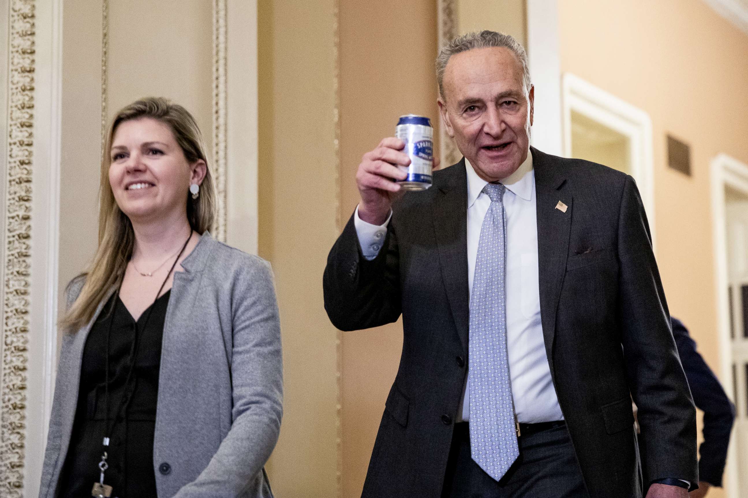 PHOTO: Chuck Schumer cheers press photographers saying, "Here's to a fair trial!" as he walks back to the Senate floor following a dinner recess in the Senate impeachment trial of President Donald Trump, Jan. 23, 2020, in Washington.
