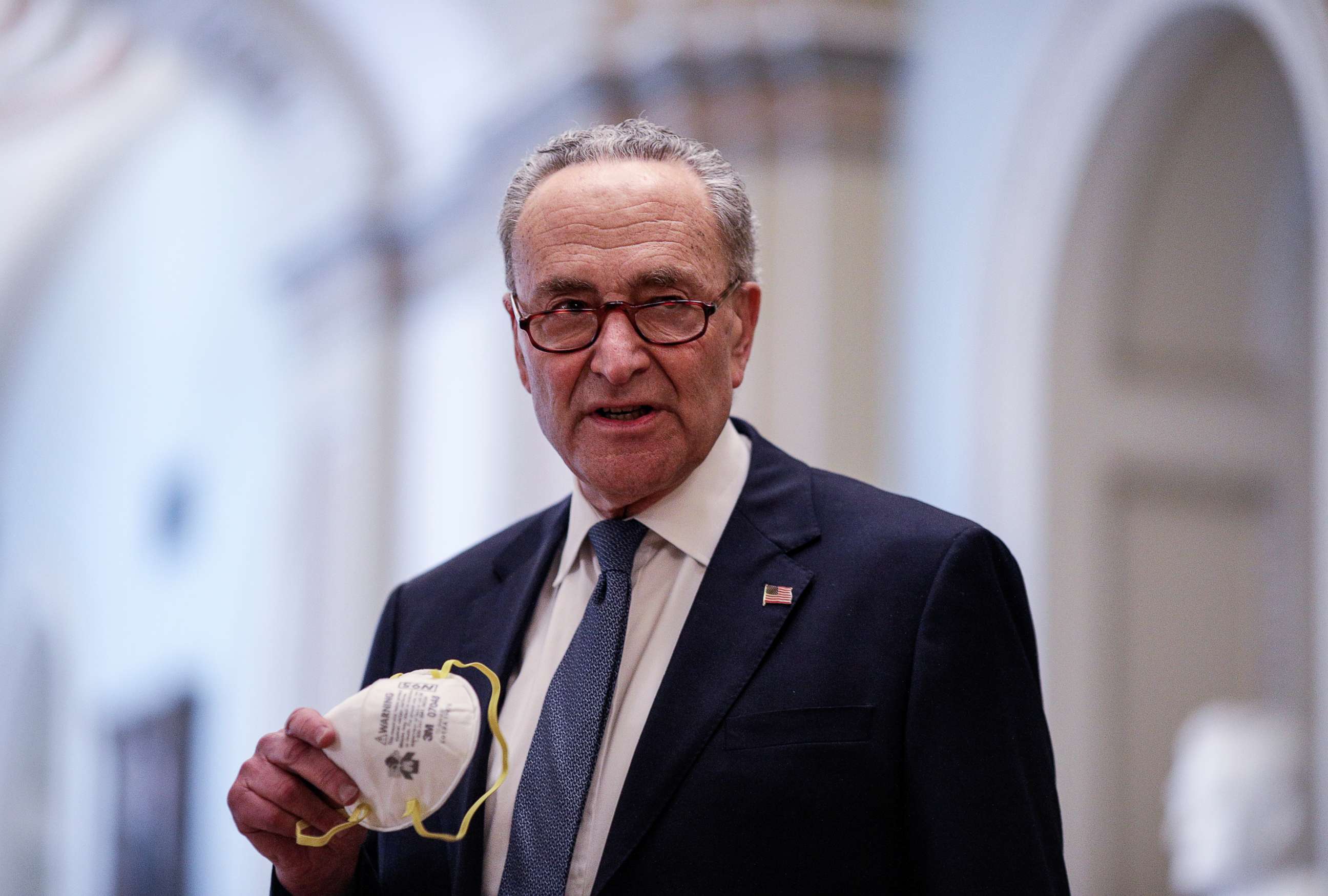 PHOTO: Senate Minority Leader Chuck Schumer carries his face mask as he arrives inside the U.S. Capitol in Washington, April 21, 2020.
