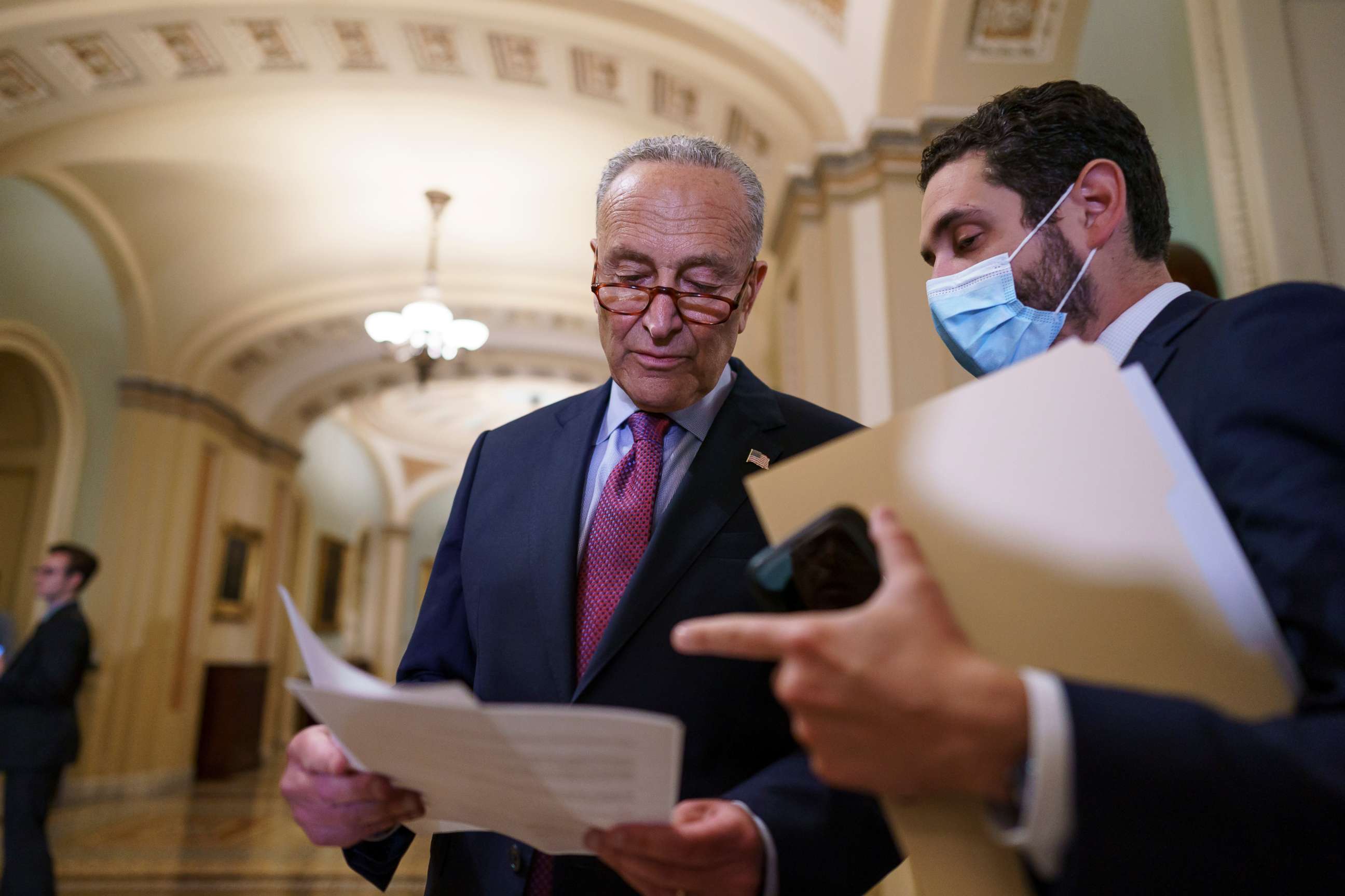 PHOTO: Senate Majority Leader Chuck Schumer, D-N.Y., looks over his notes as he talks to reporters about a procedural vote on the bipartisan infrastructure deal senators brokered with President Joe Biden, at the Capitol in Washington, July 20, 2021.